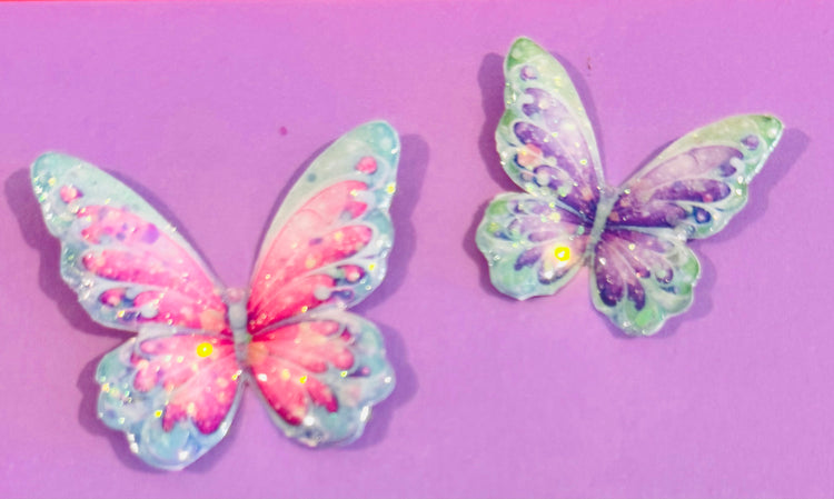 Two colorful butterfly decorations on a purple background