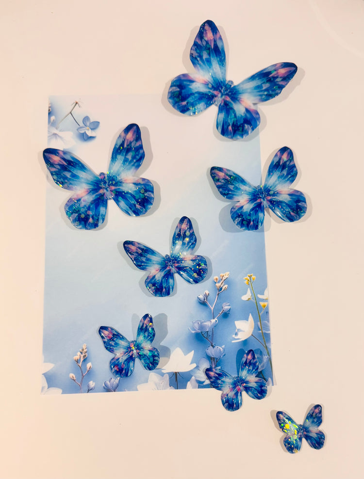 Blue butterfly decorations on a light blue card with flowers against a beige background
