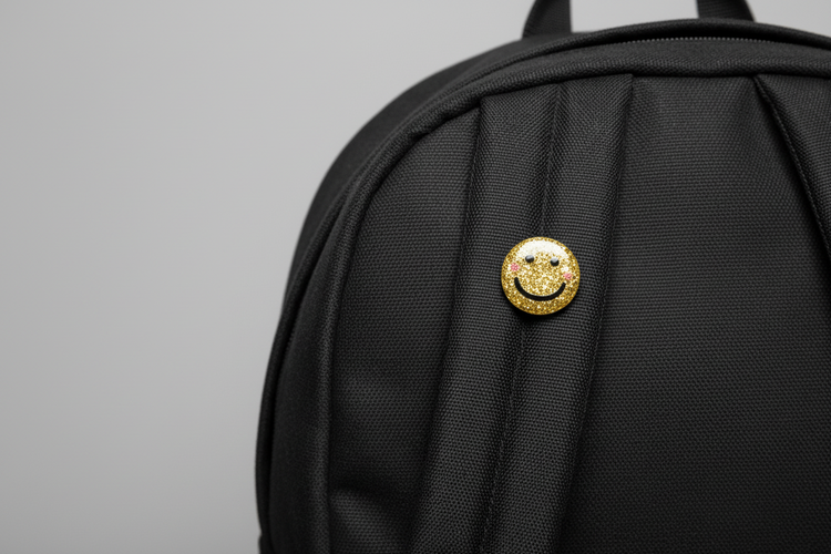 Gold glittery smiley face pin for school bag
