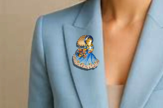 Decorative brooch with a girl in a blue dress holding an umbrella made from recycled  tin cans