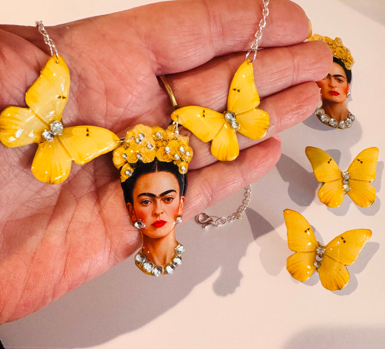 yellow butterfly earrings and a Frida Kahlo portrait pendant necklace, with additional matching earrings