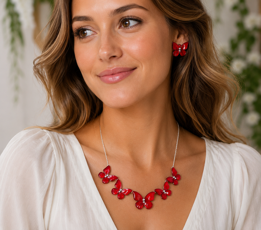 A woman wearing a red butterfly-themed statement necklace and matching red butterfly earrings
