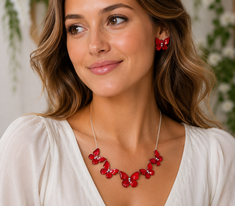 A woman wearing a red butterfly-themed statement necklace and matching red butterfly earrings