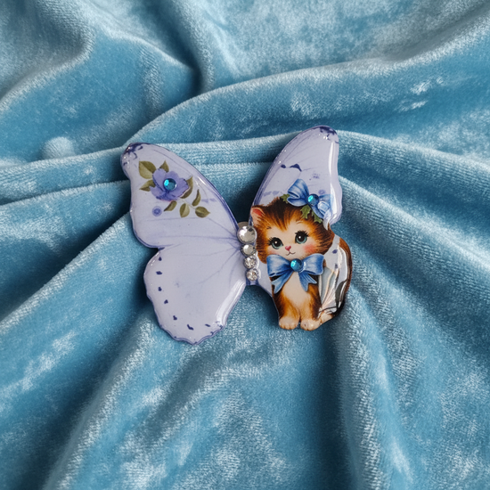 Butterfly-shaped brooch with a cat design