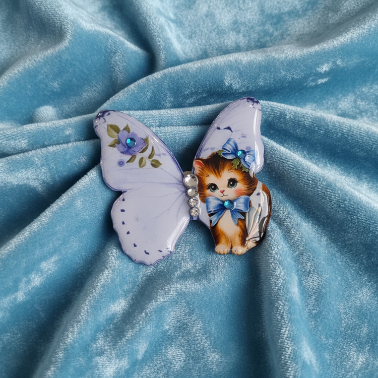 Butterfly-shaped brooch with a cat design