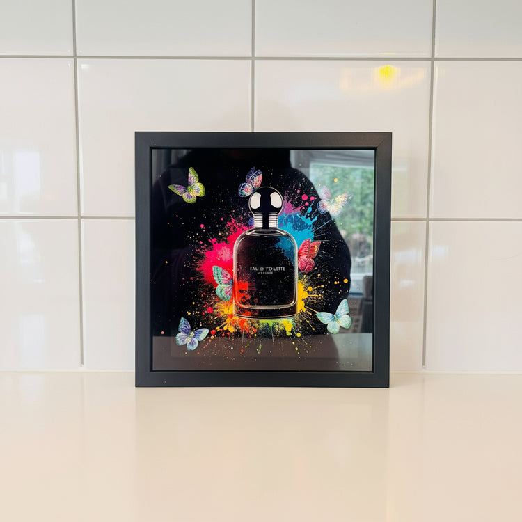 Framed artwork of a perfume bottle with colorful butterflies 