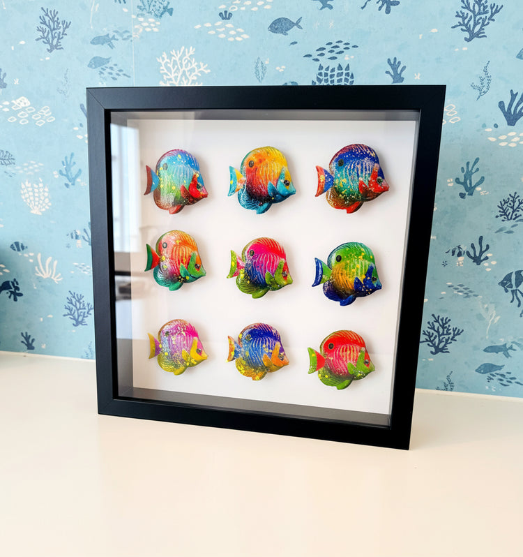 Framed artwork of colorful fish on a white background