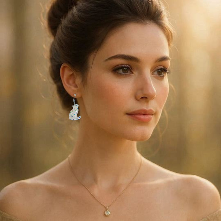 Woman wearing elegant earrings with a white cat